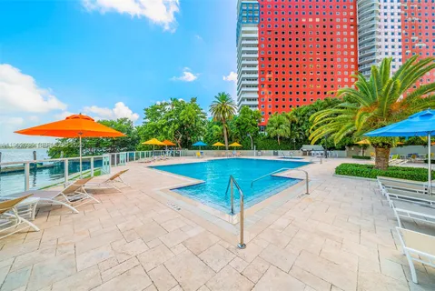 a view of a swimming pool with a chair and tables in the patio