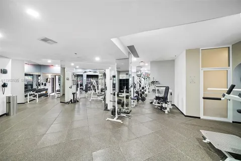 a view of a room with gym equipment and large mirror