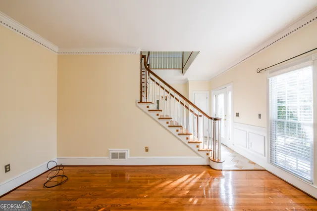 a kitchen with a refrigerator and wooden floor