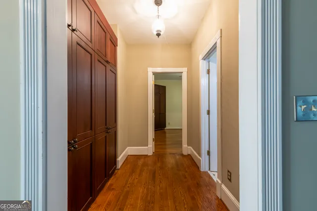 a view of a hallway with wooden floor