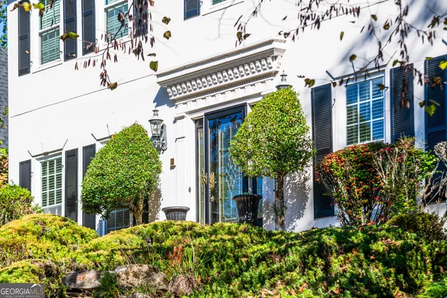 a view of an empty room with wooden floor and stairs