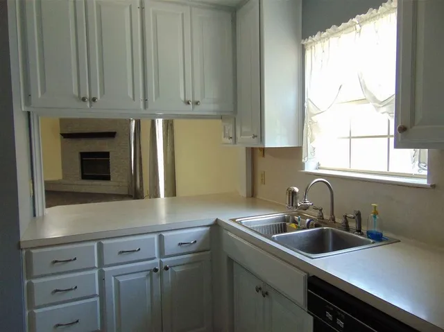 a kitchen with a sink cabinets and window