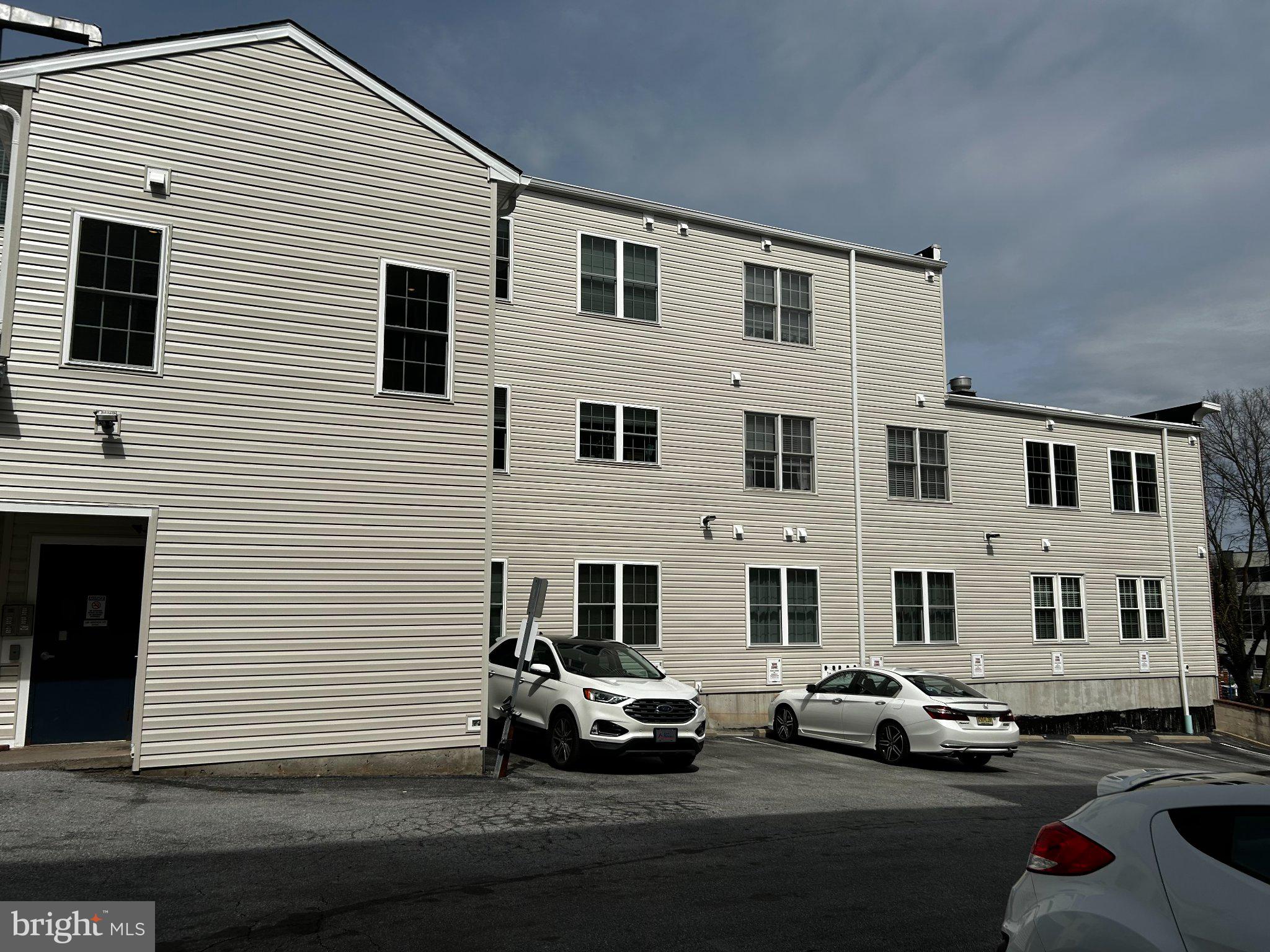 134 Bridge Street, Unit 201 Phoenixville, PA 19460 - Photo 12 of 12 a couple of cars parked in front of a house