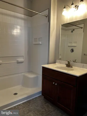 a bathroom with a bath tub sink vanity and mirror