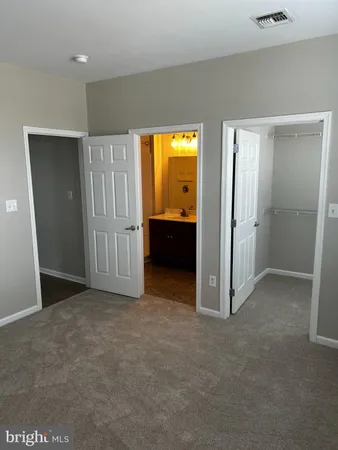 an empty room with closet and a bathroom