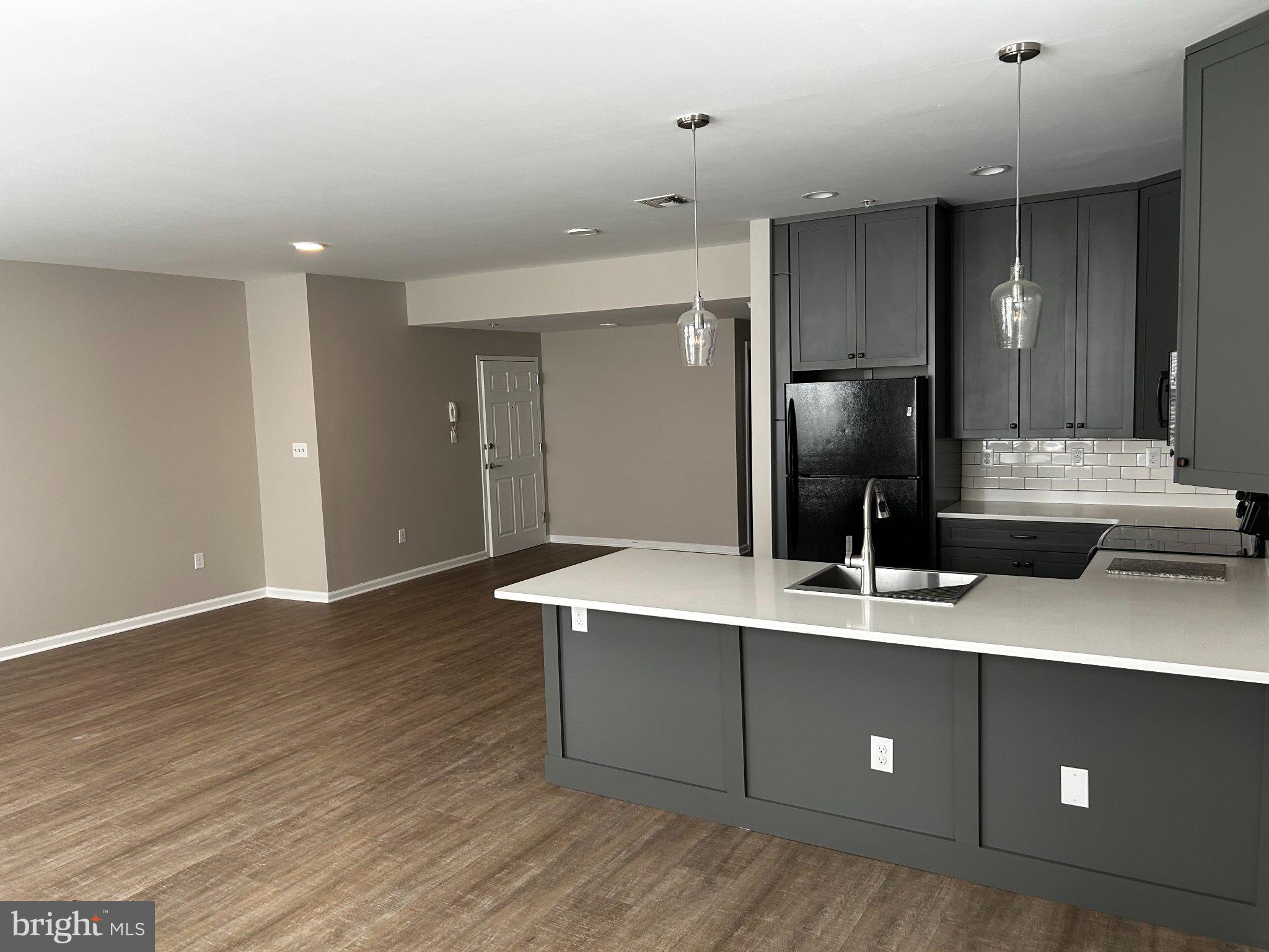 134 Bridge Street, Unit 201 Phoenixville, PA 19460 - Photo 9 of 12 a kitchen with kitchen island white cabinets and stainless steel appliances