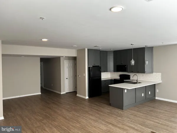 a kitchen with stainless steel appliances kitchen island granite countertop a refrigerator and a sink
