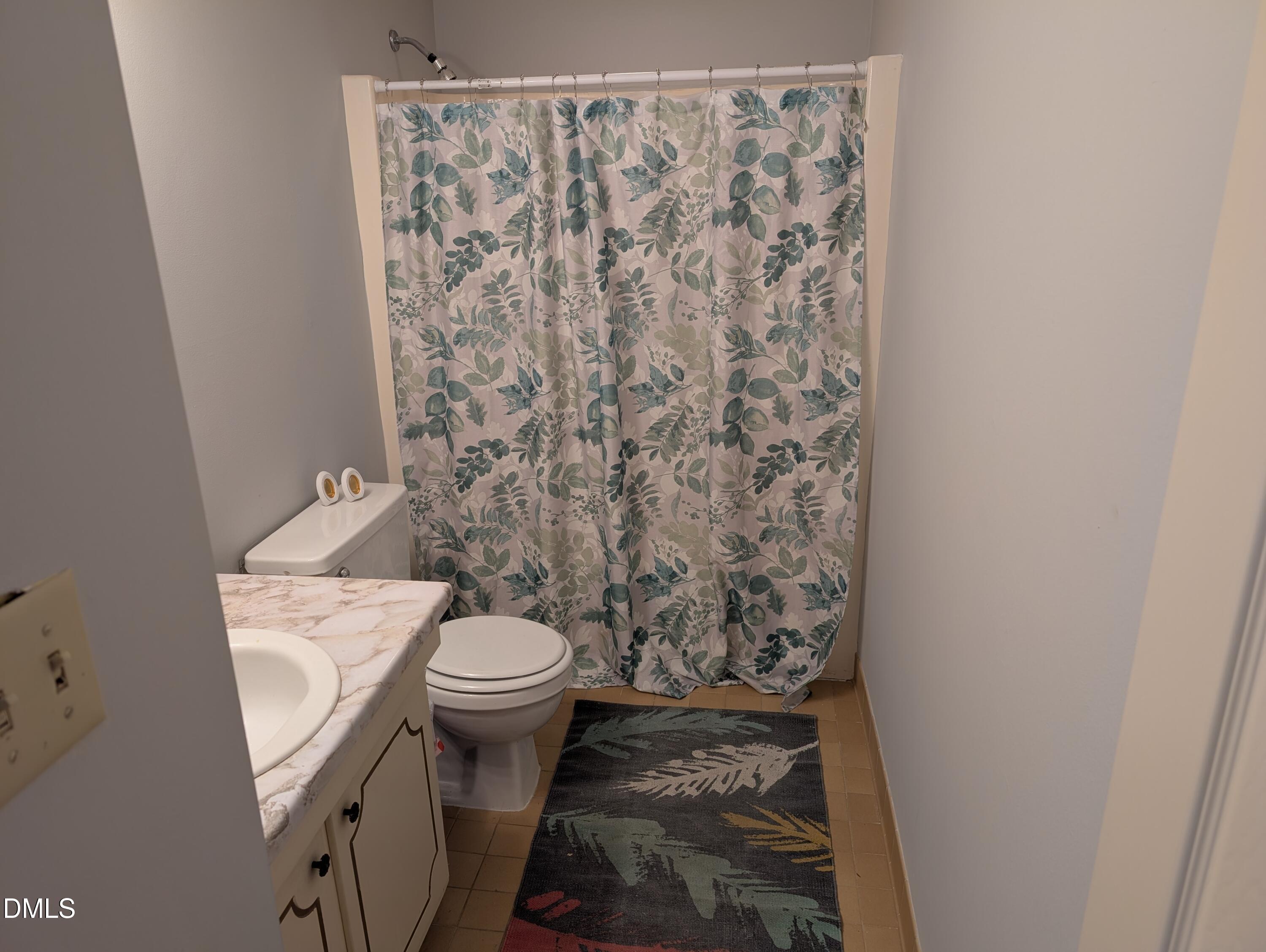 5602 Falls Of Neuse Road, Unit A Raleigh, NC 27609 - Photo 15 of 31 a white toilet sitting next to a shower curtain