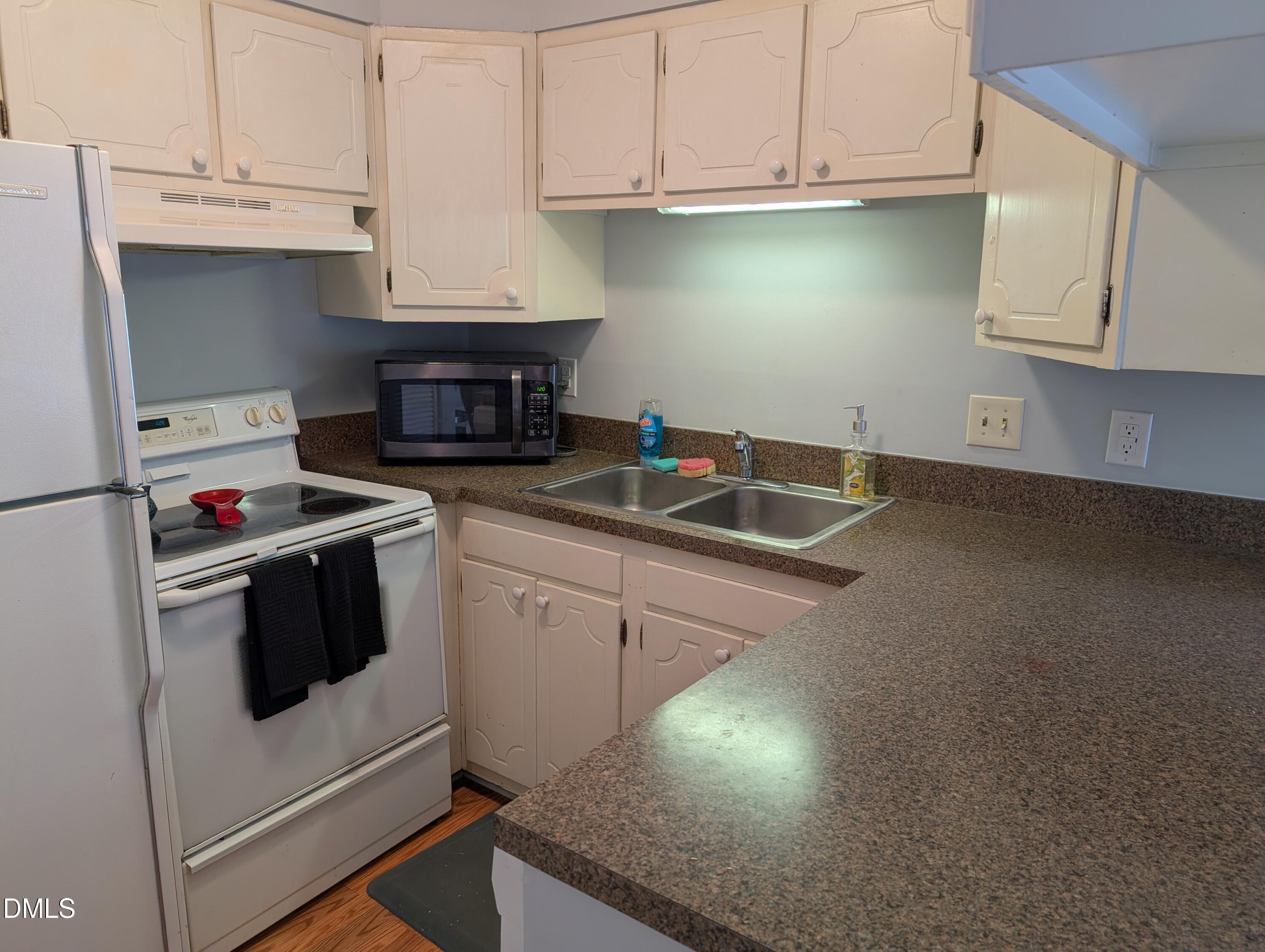5602 Falls Of Neuse Road, Unit A Raleigh, NC 27609 - Photo 18 of 31 a kitchen with granite countertop a sink dishwasher stove and white countertops with cabinets