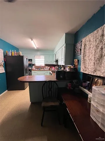 a kitchen with a table chairs and a refrigerator
