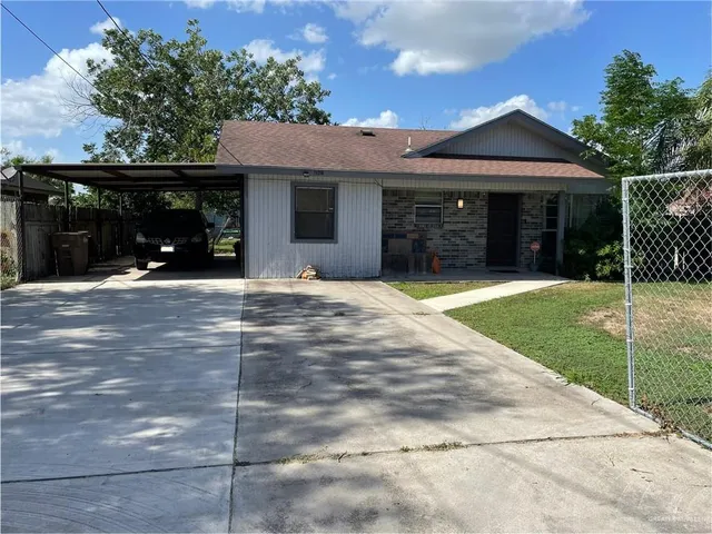 a view of a house with a yard and potted plants