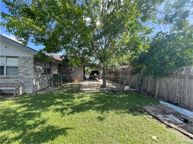 a view of a chair and table in backyard of the house