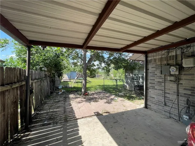 a view of a porch with wooden floor next to a yard