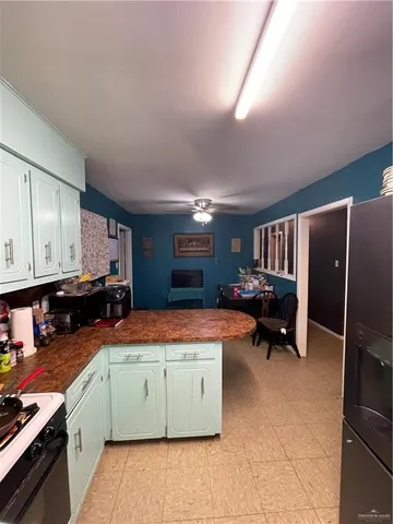 a kitchen that has a lot of cabinets in it and wooden floors