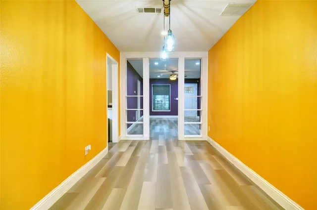 a view of a big room with wooden floor and windows