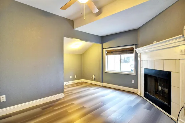 a view of an empty room with window and fire place