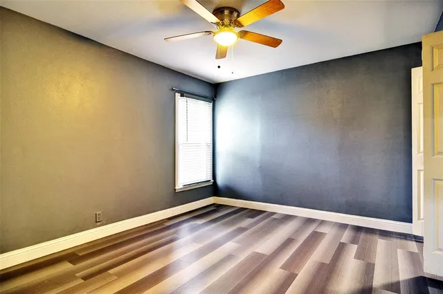 an empty room with a window and a fan