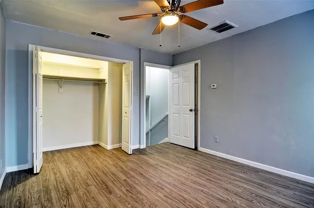 wooden floor in an empty room with a fan