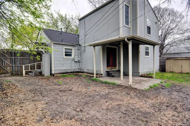 a view of a house with a yard and large tree