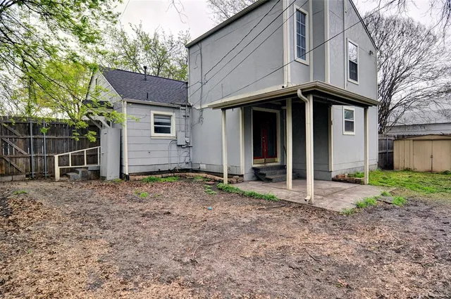 a view of a house with a yard and large tree