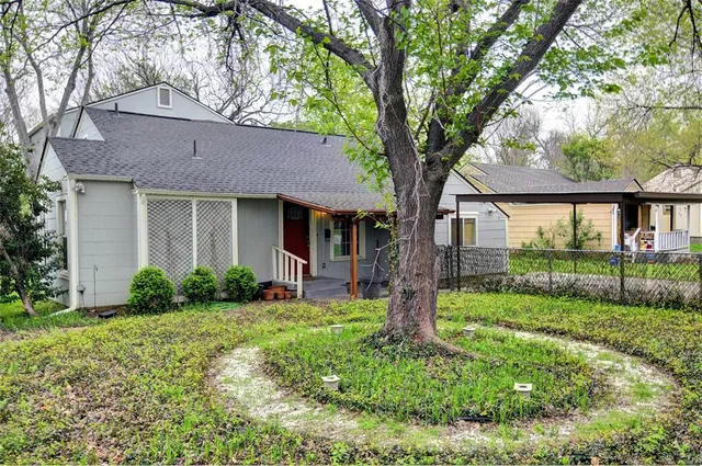 a view of a house with backyard and a tree