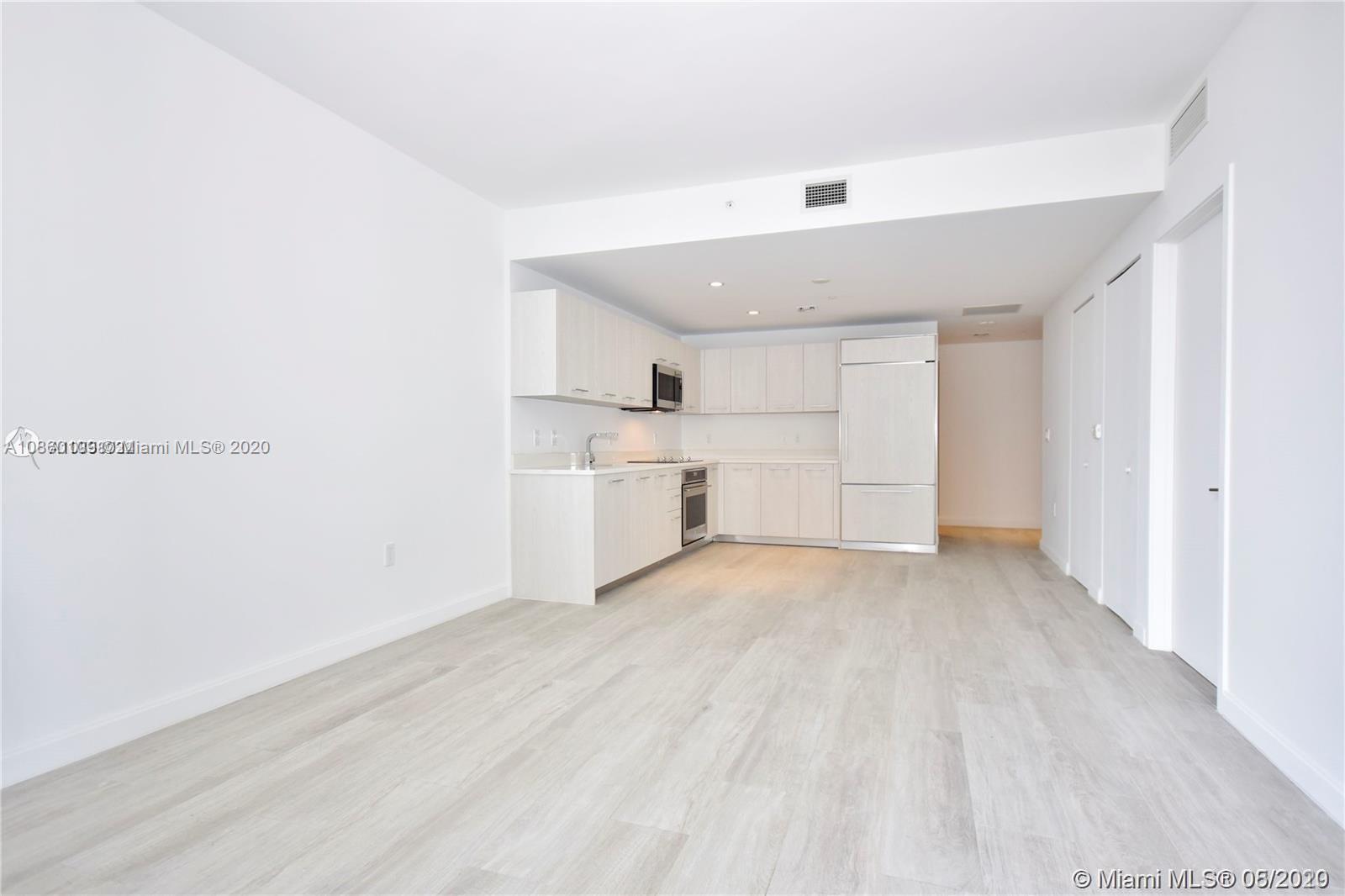 55 Southwest 9th Street, Unit 2210 Miami, FL 33130 - Photo 21 of 24 a view of a kitchen with a sink and dishwasher a refrigerator with white cabinets