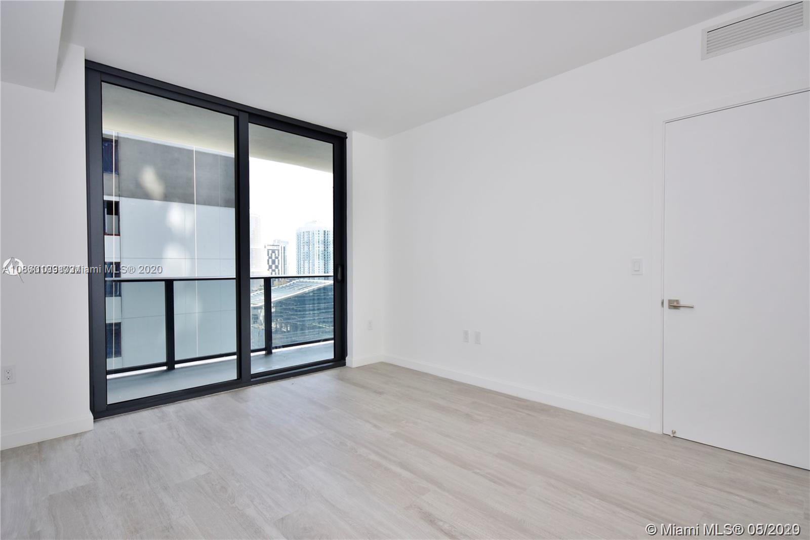55 Southwest 9th Street, Unit 2210 Miami, FL 33130 - Photo 23 of 24 an empty room with sliding glass door and mirror
