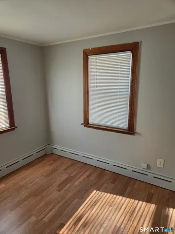 a view of a room with wooden floor and a window