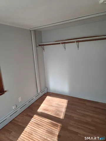 a view of a room with wooden floor and bench