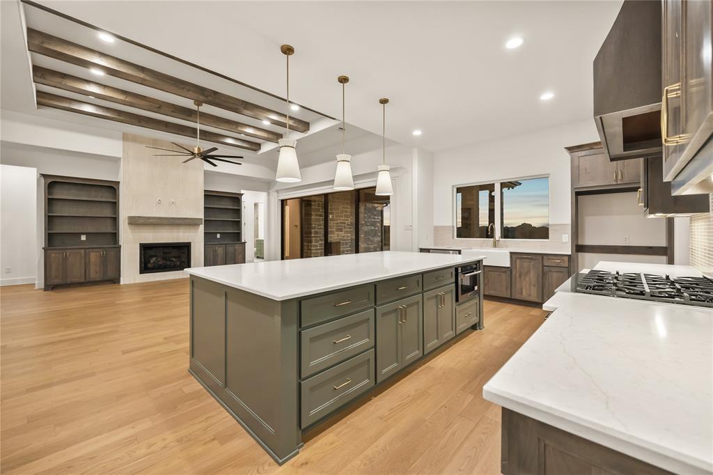 1031 Ranch Vista Road Granbury, TX 76049 - Photo 10 of 32 Gourmet kitchen with white countertops and a large central island, featuring a built-in microwave