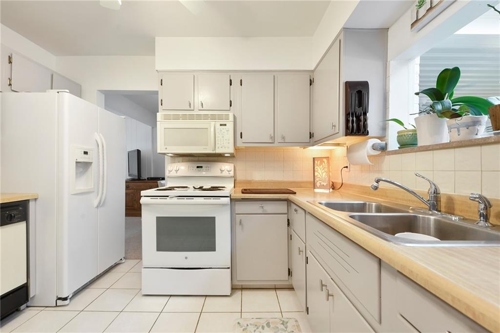 1323 Oakridge Road Bridgeville, PA 15017 - Photo 12 of 36 a kitchen with stainless steel appliances granite countertop a sink stove and refrigerator
