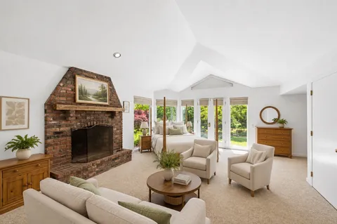 a living room with furniture a fireplace and a large window