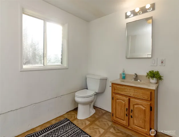 a bathroom with a sink toilet and window