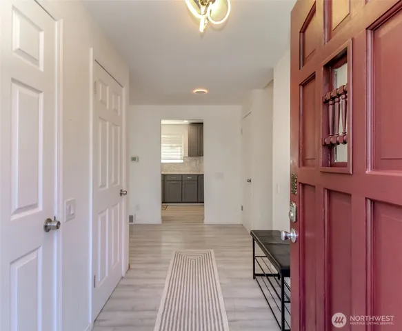 a view of a hallway with wooden floor and entryway