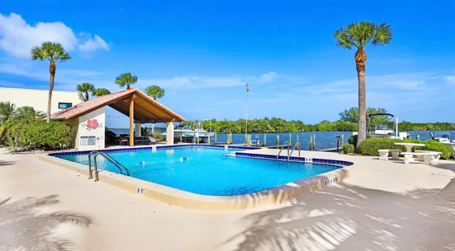 a view of a house with pool and chairs