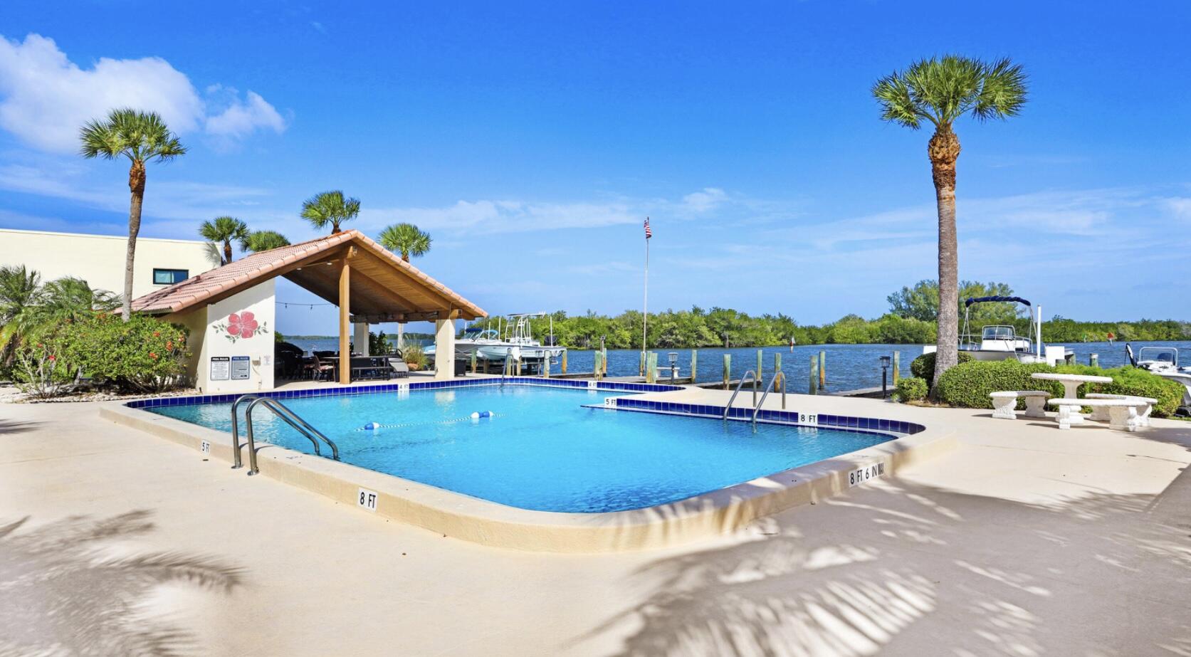 1617 Minutemen Causeway, Unit 202 Cocoa Beach, FL 32931 - Photo 1 of 20 a view of a house with pool and chairs