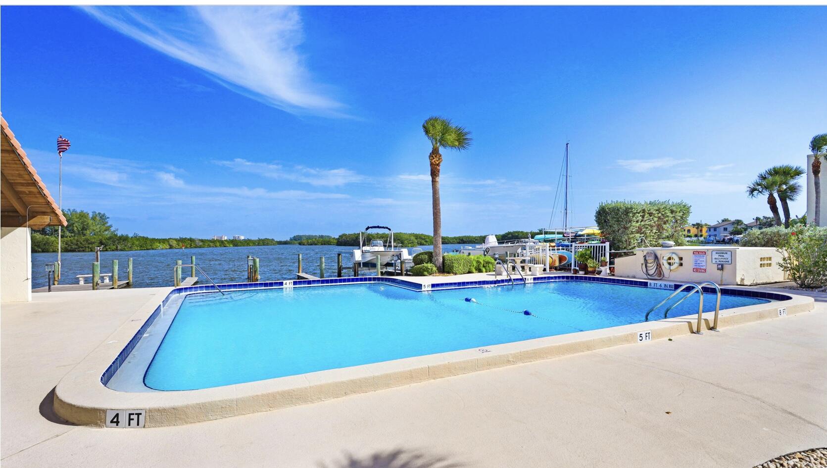 1617 Minutemen Causeway, Unit 202 Cocoa Beach, FL 32931 - Photo 18 of 20 a view of a swimming pool with a lawn chairs