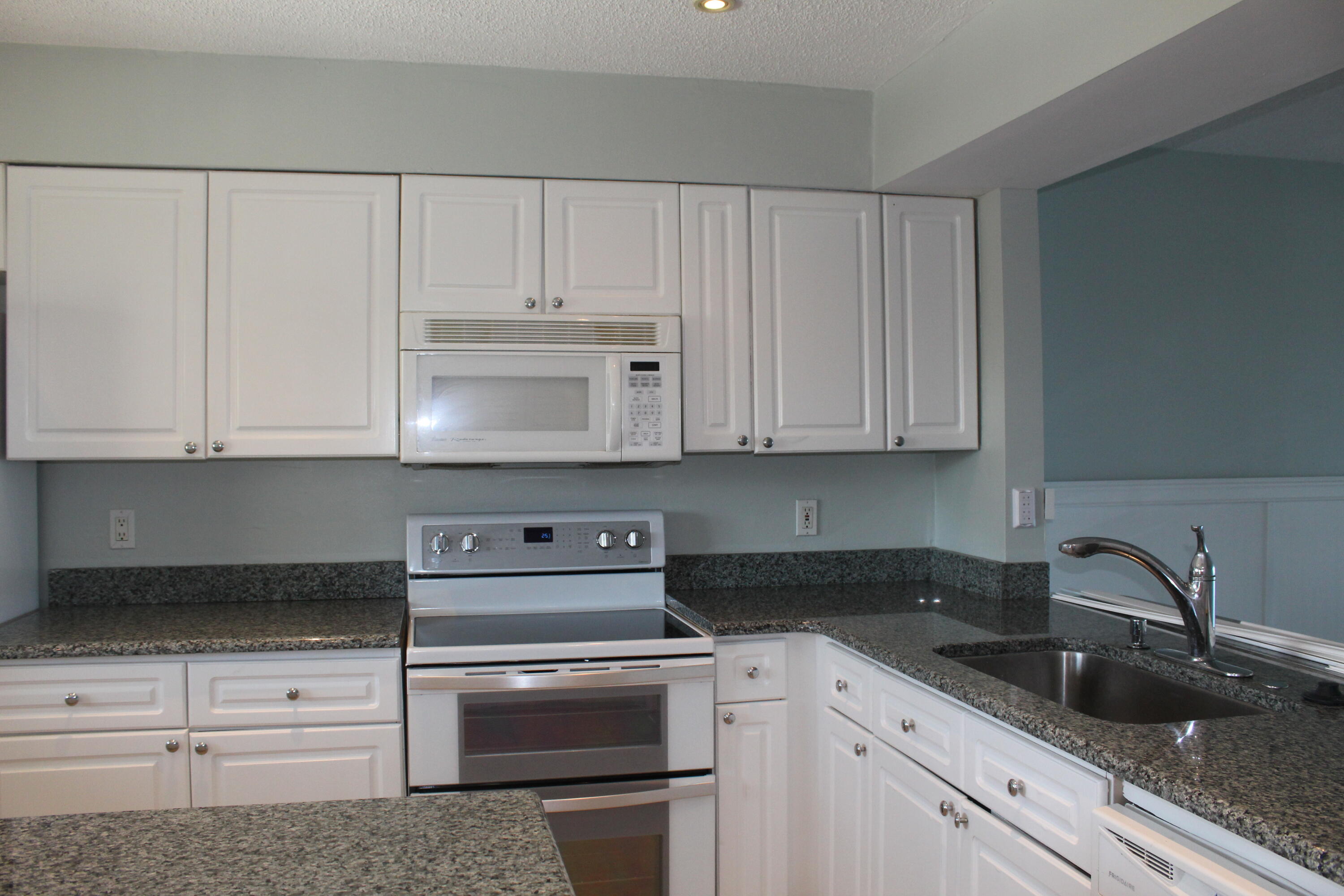 1617 Minutemen Causeway, Unit 202 Cocoa Beach, FL 32931 - Photo 5 of 20 a kitchen with white cabinets and sink
