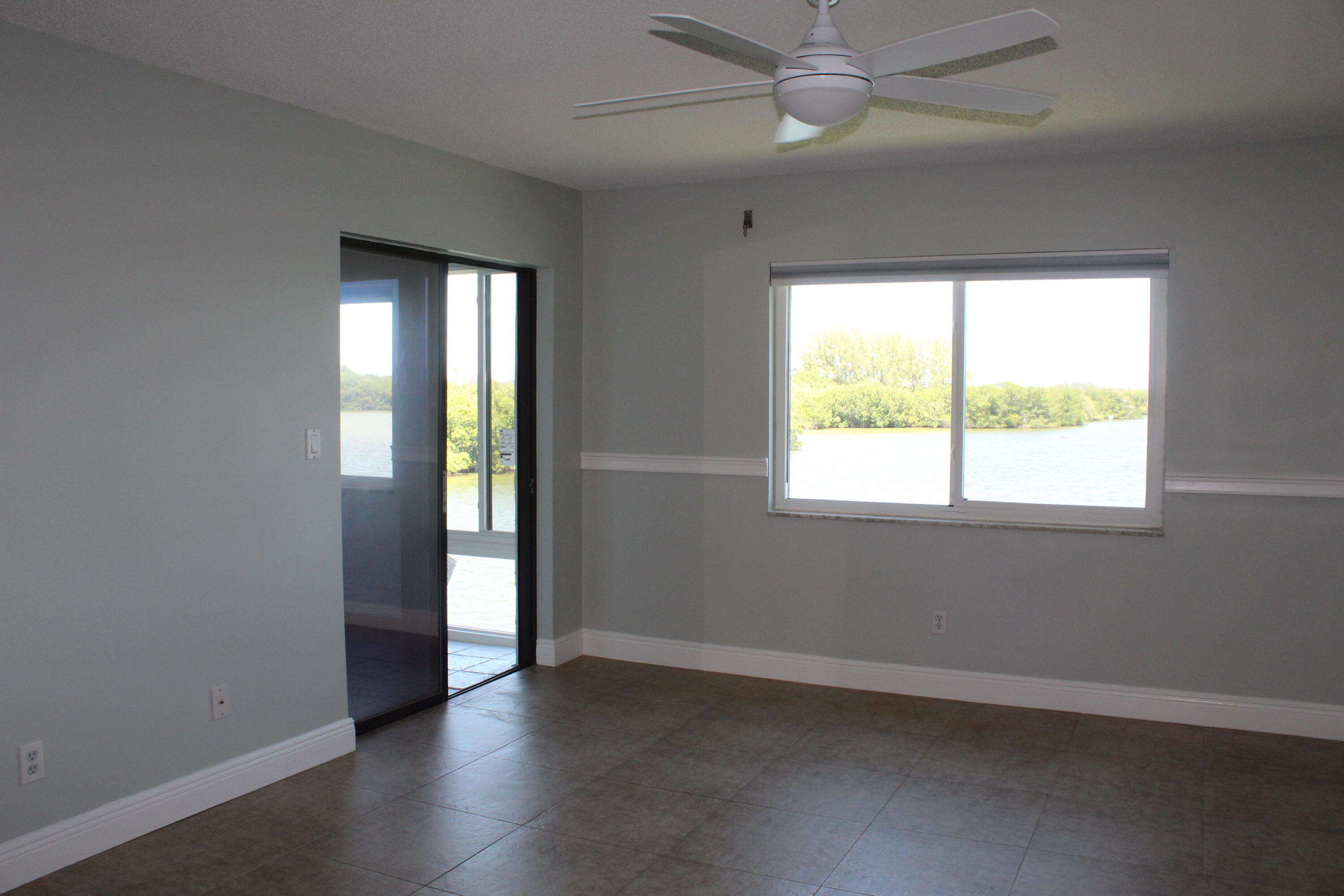 1617 Minutemen Causeway, Unit 202 Cocoa Beach, FL 32931 - Photo 8 of 20 an empty room with wooden floor and windows