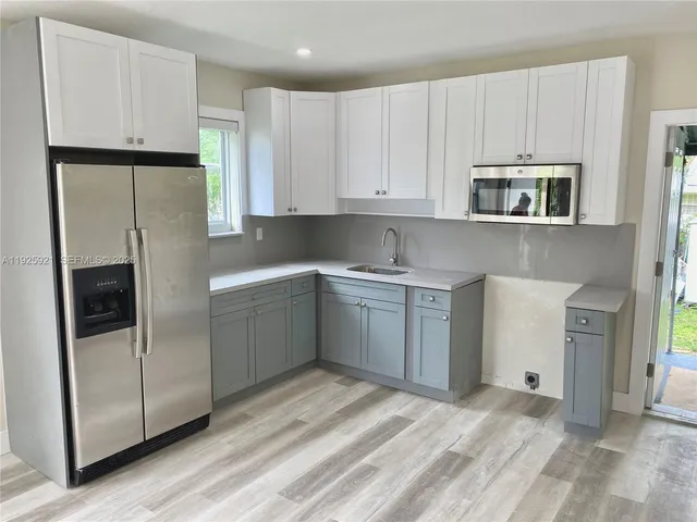 a kitchen with white cabinets and white appliances