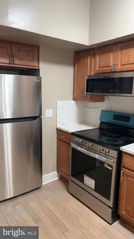 a kitchen with granite countertop a stove and a refrigerator