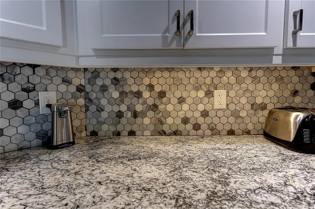 a view of kitchen with granite countertop cabinets and refrigerator