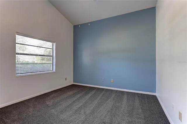 a kitchen with white cabinets and window