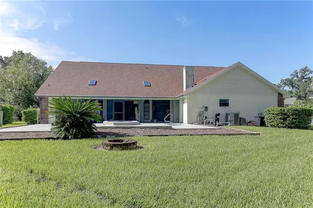 a view of house with yard and outdoor seating