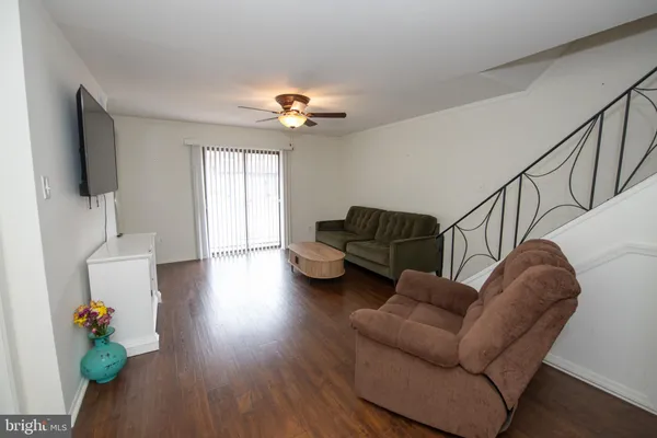 a living room with furniture ceiling fan and a flat screen tv