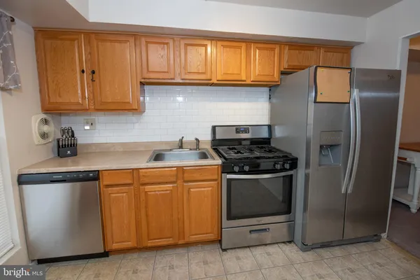 a kitchen with stainless steel appliances granite countertop a stove a refrigerator and a sink