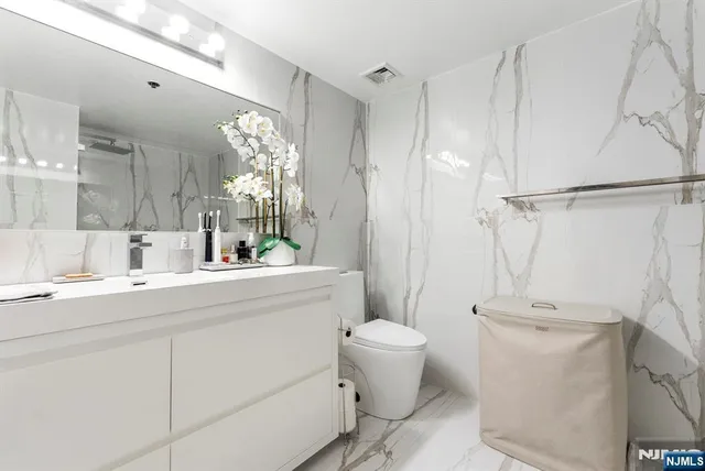 a bathroom with a toilet sink and mirror