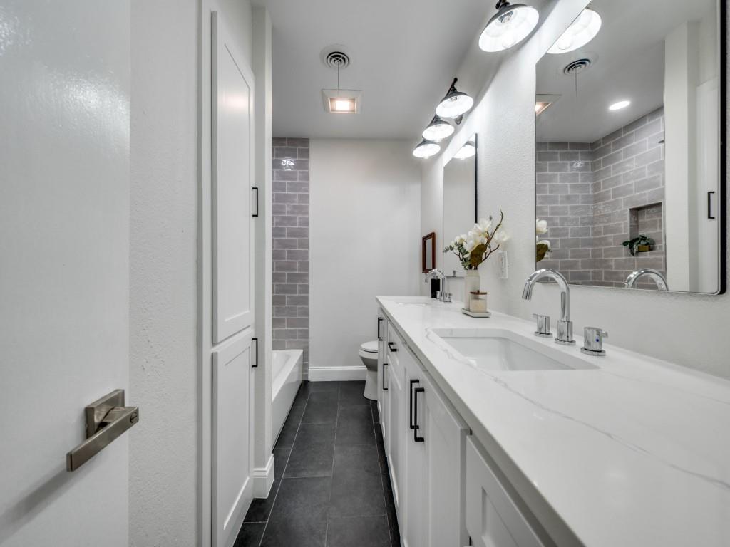 3406 Springwood Lane Dallas, TX 75233 - Photo 23 of 36 a bathroom with a double vanity sink and a mirror