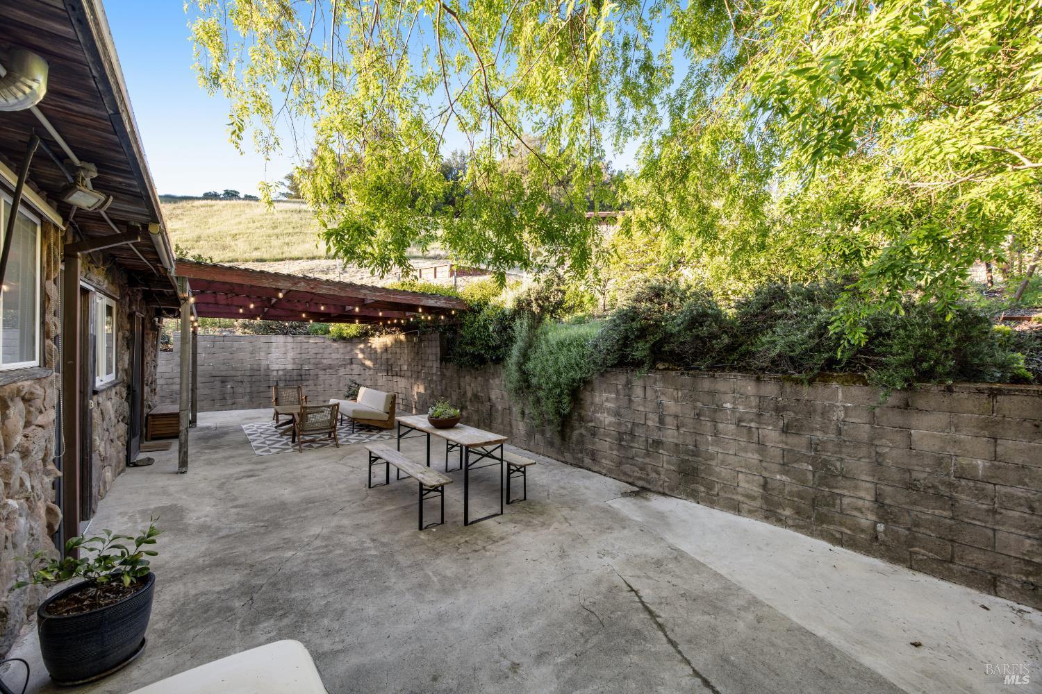 6960 Round Oak Road Penngrove, CA 94951 - Photo 45 of 58 a view of a patio with table and chairs potted plants with large tree