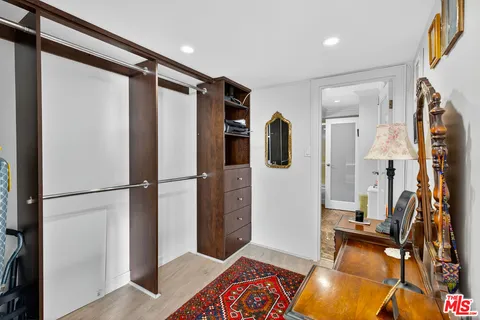 a view of walk in closet with clothes and shoes